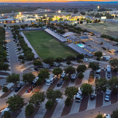 A view of large RVs parked on wide, paved sites at Flag City RV Resort in Lodi, CA.