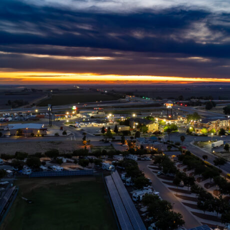 A view of large RVs parked on wide, paved sites at Flag City RV Resort in Lodi, CA.