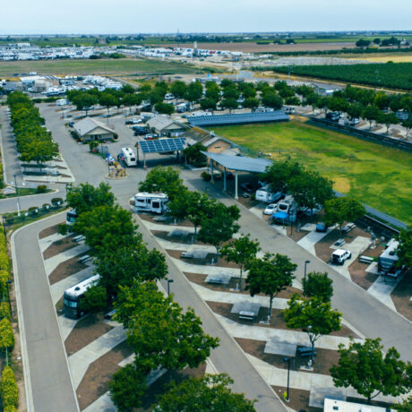 A view of large RVs parked on wide, paved sites at Flag City RV Resort in Lodi, CA.