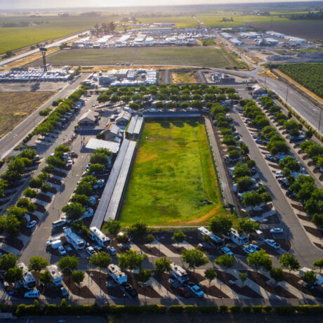 A view of large RVs parked on wide, paved sites at Flag City RV Resort in Lodi, CA.