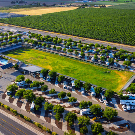 A view of large RVs parked on wide, paved sites at Flag City RV Resort in Lodi, CA.