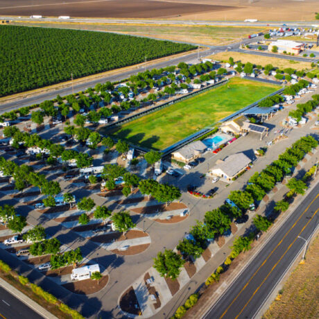 A view of large RVs parked on wide, paved sites at Flag City RV Resort in Lodi, CA.