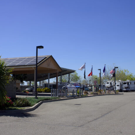 View of the flags waving an RV Sites at Flag City RV Resort in Lodi, CA.