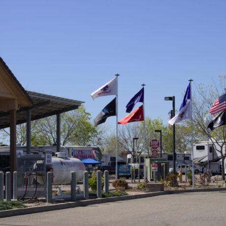 View of the flags waving an RV Sites at Flag City RV Resort in Lodi, CA.